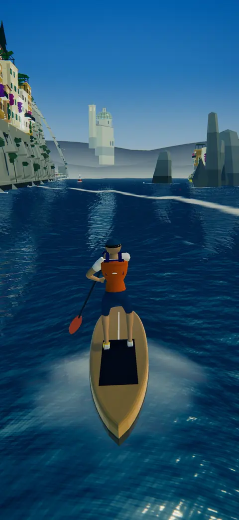 A paddleboarder off a cliffside town of colorful houses on the Amalfi coast.